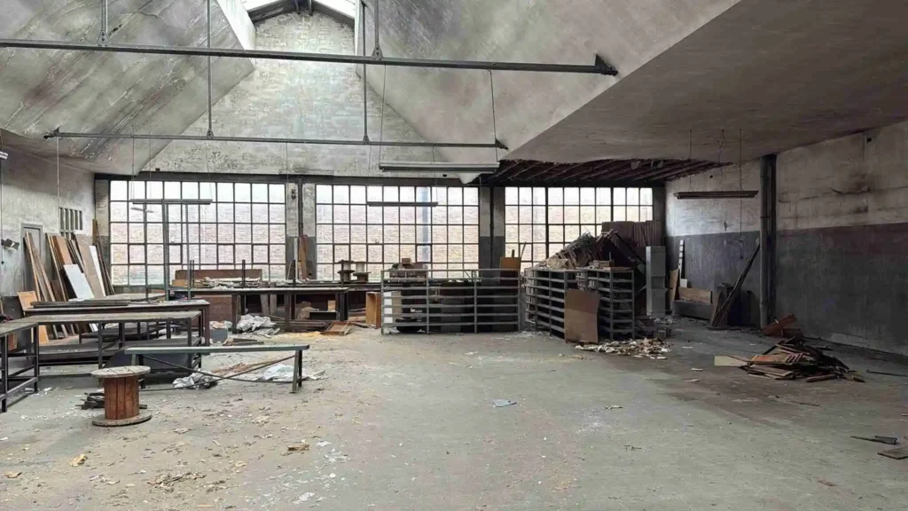 Nave industrial con mobiliario y restos antes de su vaciado